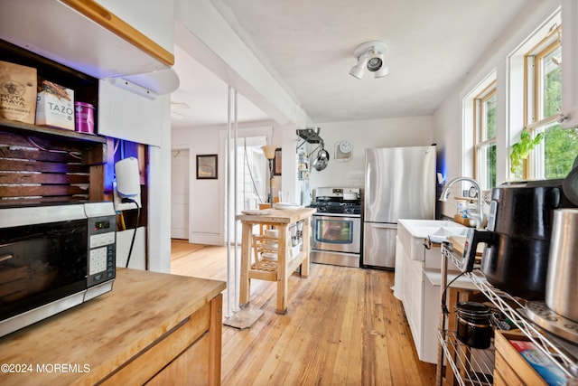 kitchen featuring sink, appliances with stainless steel finishes, and light hardwood / wood-style floors