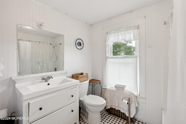 bathroom featuring vanity, wooden walls, tile patterned floors, toilet, and a shower with shower curtain