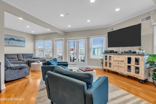 living room with light hardwood / wood-style flooring and ornamental molding