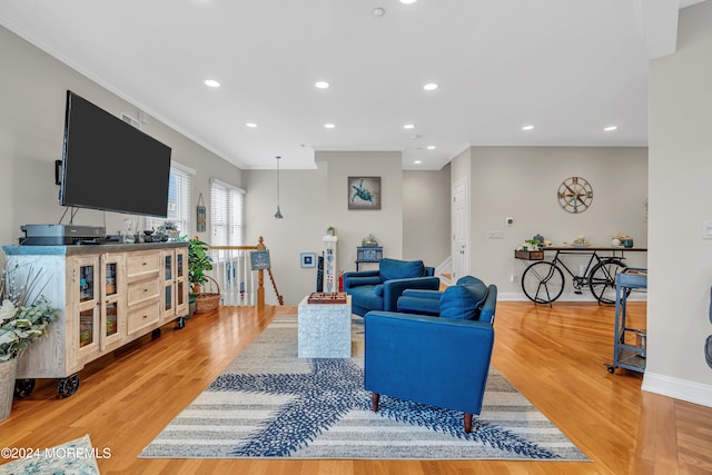 living room featuring light wood-type flooring and ornamental molding