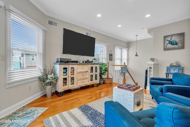 living room featuring a wealth of natural light, hardwood / wood-style floors, and crown molding