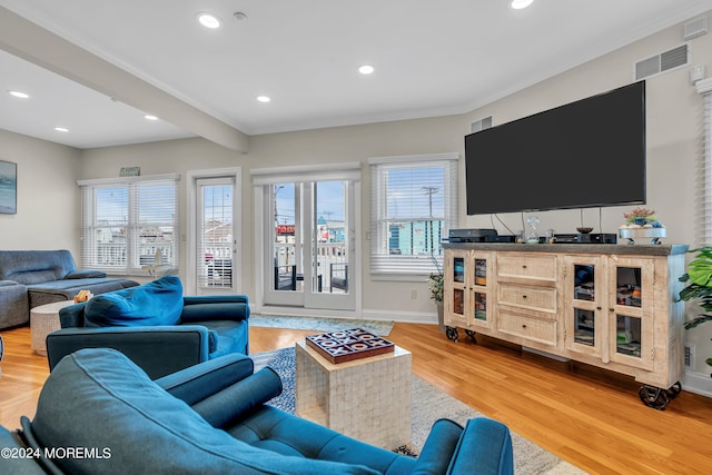 living room with wood-type flooring, beamed ceiling, and crown molding