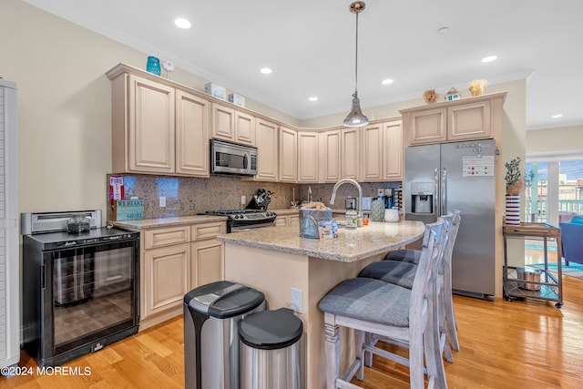 kitchen featuring wine cooler, light stone counters, light hardwood / wood-style flooring, appliances with stainless steel finishes, and ornamental molding