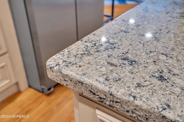 details featuring light wood-type flooring and light stone counters