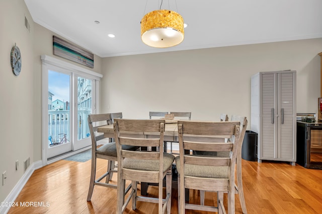 dining room featuring ornamental molding and light hardwood / wood-style floors