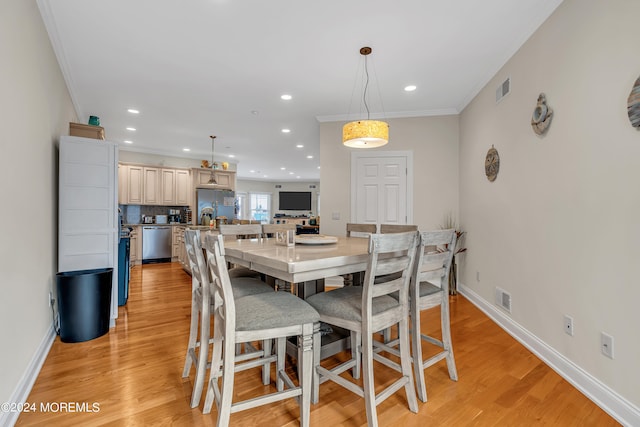 dining space featuring ornamental molding and light hardwood / wood-style floors