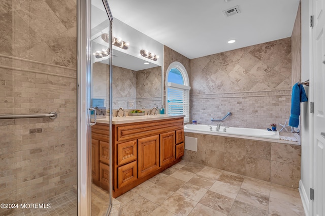 bathroom featuring vanity, tile walls, and shower with separate bathtub