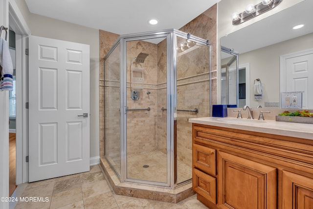 bathroom featuring vanity, a shower with shower door, and tile patterned floors