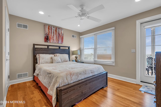 bedroom featuring ceiling fan, multiple windows, and hardwood / wood-style floors