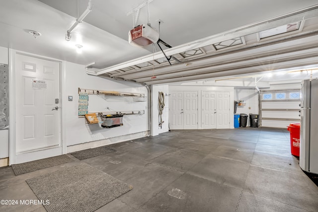 garage featuring a garage door opener and white refrigerator