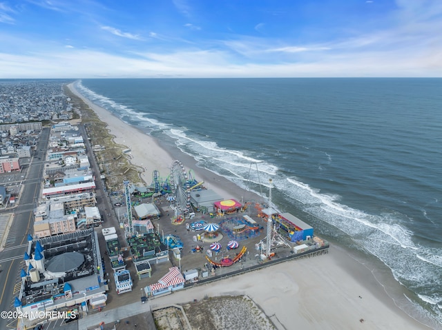 birds eye view of property with a water view and a beach view