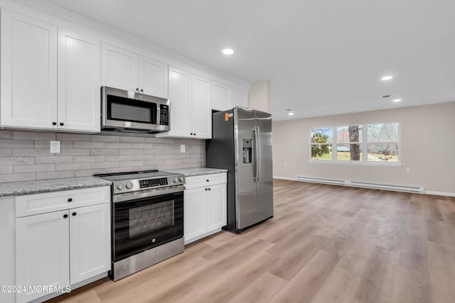 kitchen with white cabinets, decorative backsplash, light hardwood / wood-style floors, and appliances with stainless steel finishes