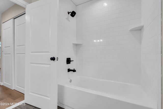 bathroom with tiled shower / bath combo and hardwood / wood-style flooring