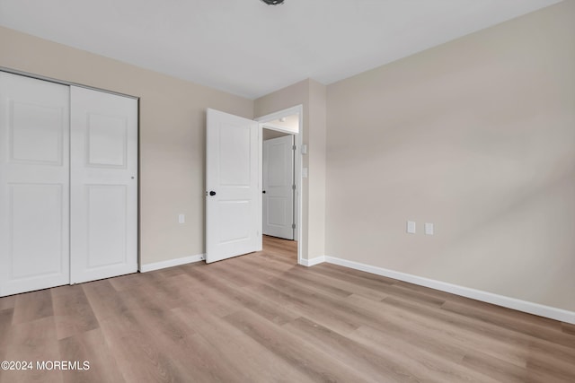 unfurnished bedroom with light hardwood / wood-style floors and a closet