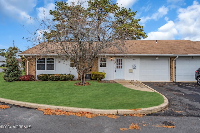 ranch-style home with a front lawn, central AC unit, and a garage