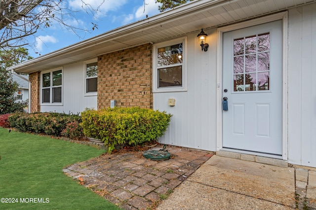 view of exterior entry with a yard