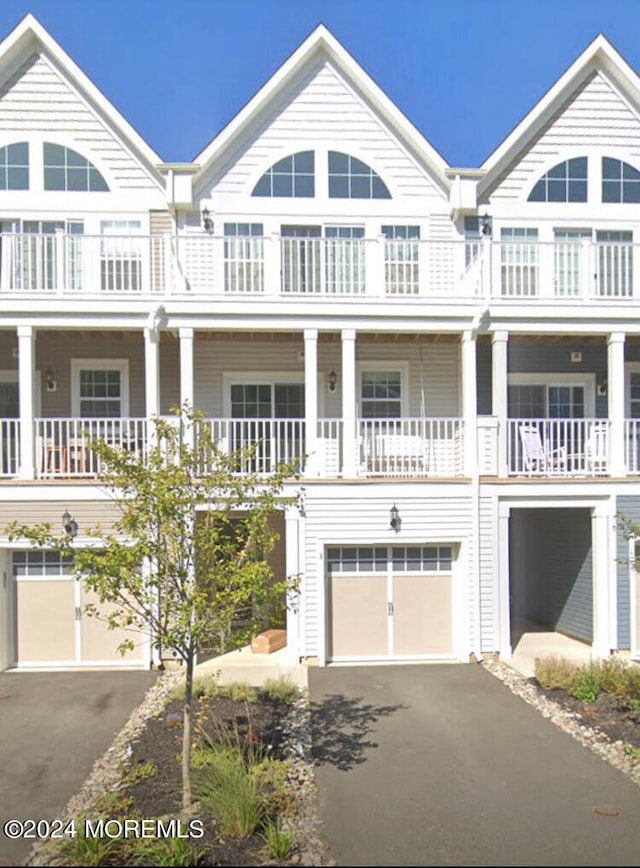 view of front of house featuring a balcony, a porch, and a garage