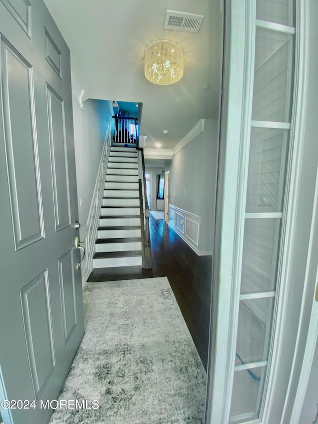 stairs featuring ornamental molding and hardwood / wood-style floors