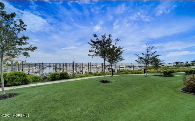 view of home's community featuring a lawn and a water view