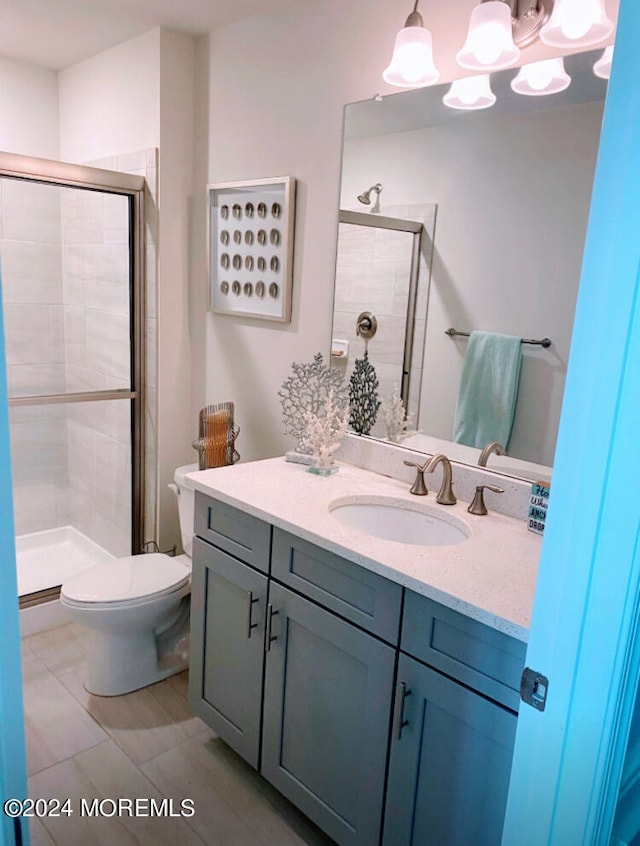 bathroom with walk in shower, vanity, toilet, and tile patterned floors