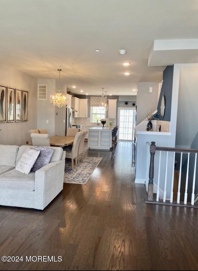 living room featuring an inviting chandelier and dark hardwood / wood-style flooring