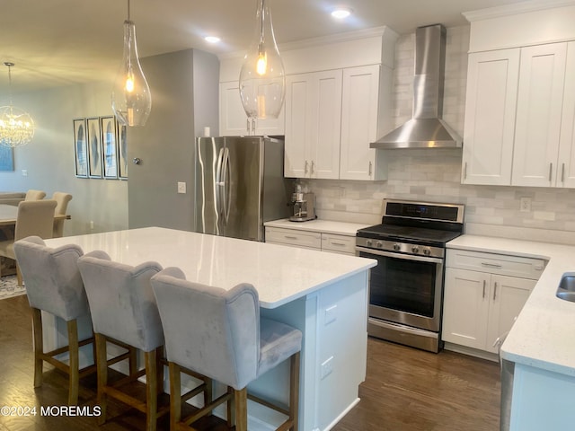 kitchen featuring white cabinetry, appliances with stainless steel finishes, dark hardwood / wood-style floors, and wall chimney range hood