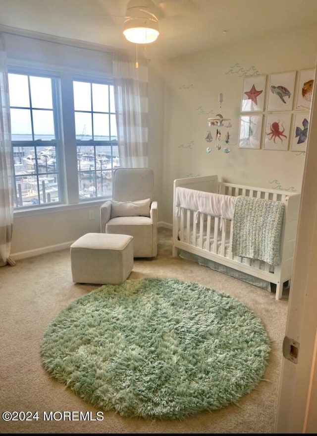 carpeted bedroom featuring ceiling fan, a nursery area, and vaulted ceiling