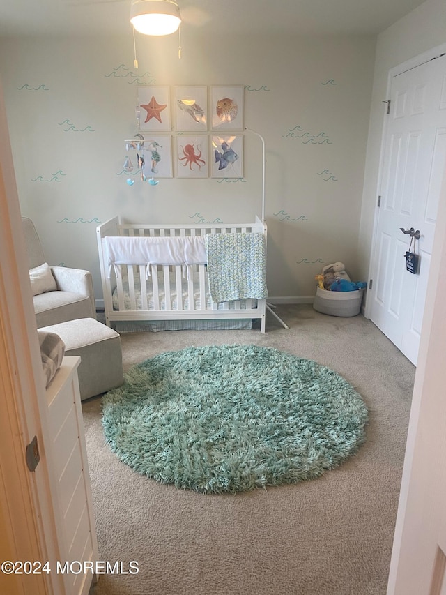 carpeted bedroom featuring a nursery area