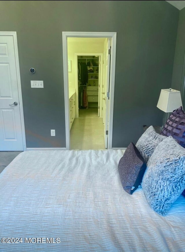 bedroom with light colored carpet and a spacious closet