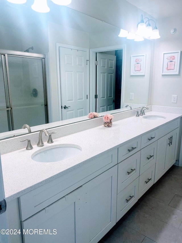 bathroom featuring vanity, a shower with shower door, and tile patterned floors