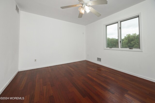 empty room with dark hardwood / wood-style flooring and ceiling fan