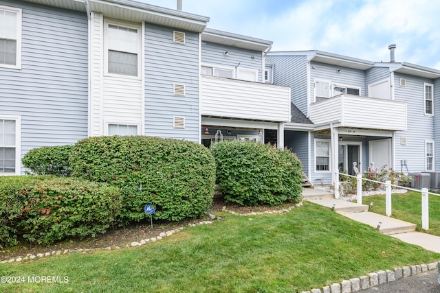 exterior space featuring a front yard, a balcony, and central air condition unit