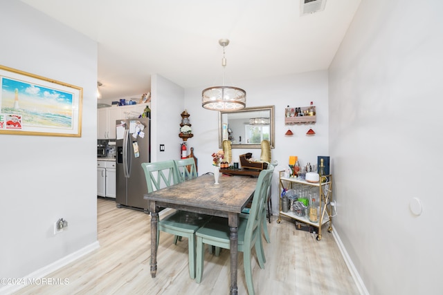 dining room featuring light hardwood / wood-style flooring and an inviting chandelier