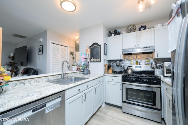 kitchen featuring white cabinets, sink, tasteful backsplash, appliances with stainless steel finishes, and light wood-type flooring