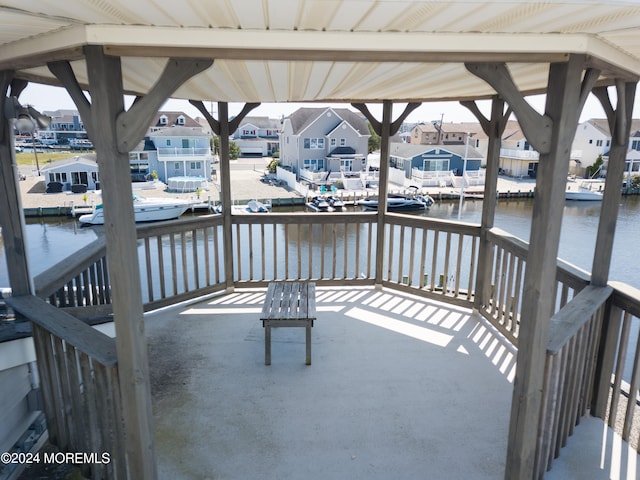 wooden terrace featuring a water view and a porch