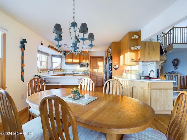 dining space featuring light hardwood / wood-style flooring, an inviting chandelier, and sink