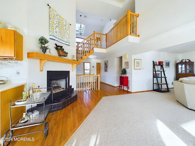 living room featuring a fireplace, hardwood / wood-style floors, and a high ceiling