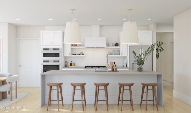 kitchen with light hardwood / wood-style flooring, an island with sink, decorative light fixtures, and white cabinetry