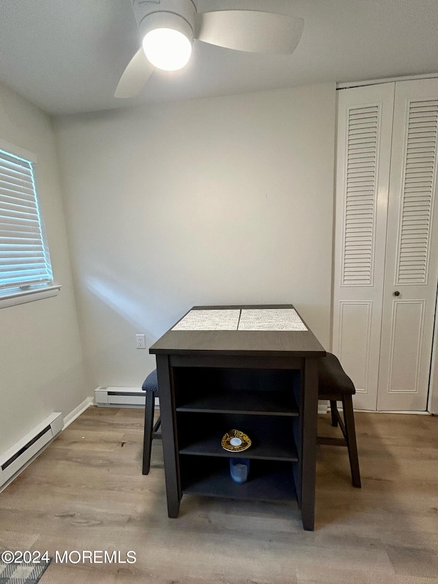 dining area with ceiling fan, light hardwood / wood-style flooring, and a baseboard heating unit