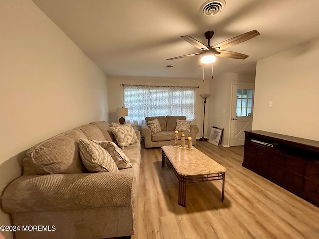 living room featuring a wealth of natural light, light hardwood / wood-style floors, and ceiling fan