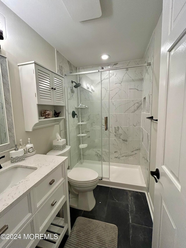 bathroom featuring vanity, toilet, and a shower with door