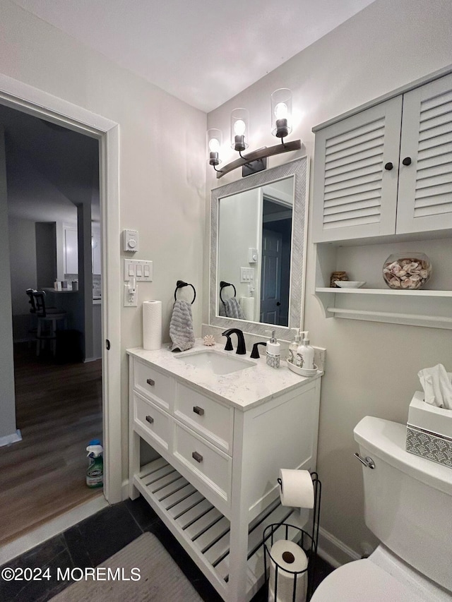 bathroom with vanity, hardwood / wood-style floors, and toilet