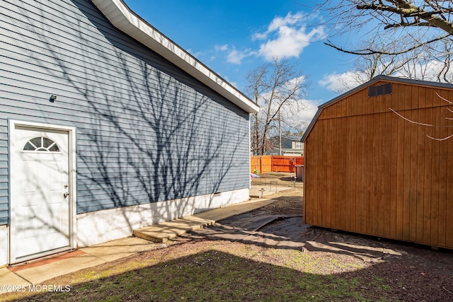 view of side of home featuring fence, an outbuilding, and crawl space