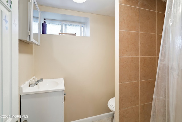 bathroom featuring vanity, toilet, and a tile shower