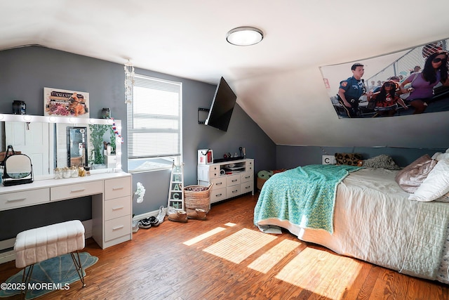 bedroom with vaulted ceiling and light wood-style floors