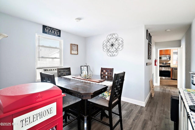 dining space featuring dark wood finished floors and baseboards