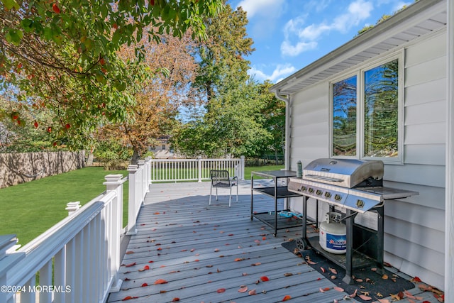 wooden terrace with area for grilling and a lawn