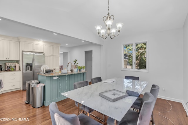 dining space featuring lofted ceiling, an inviting chandelier, and hardwood / wood-style floors