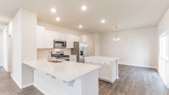 kitchen with kitchen peninsula, decorative light fixtures, white cabinetry, stainless steel appliances, and dark hardwood / wood-style floors