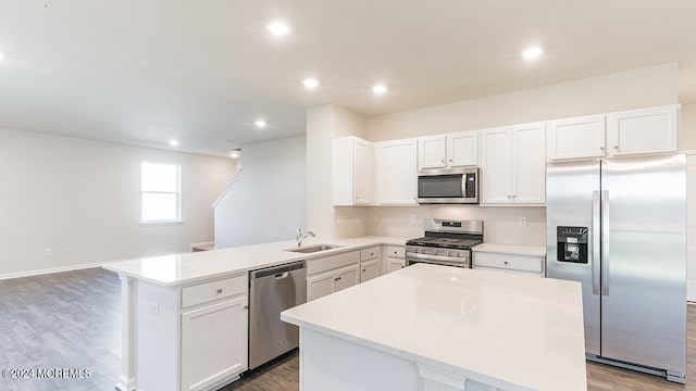 kitchen featuring white cabinets, appliances with stainless steel finishes, sink, and a kitchen island